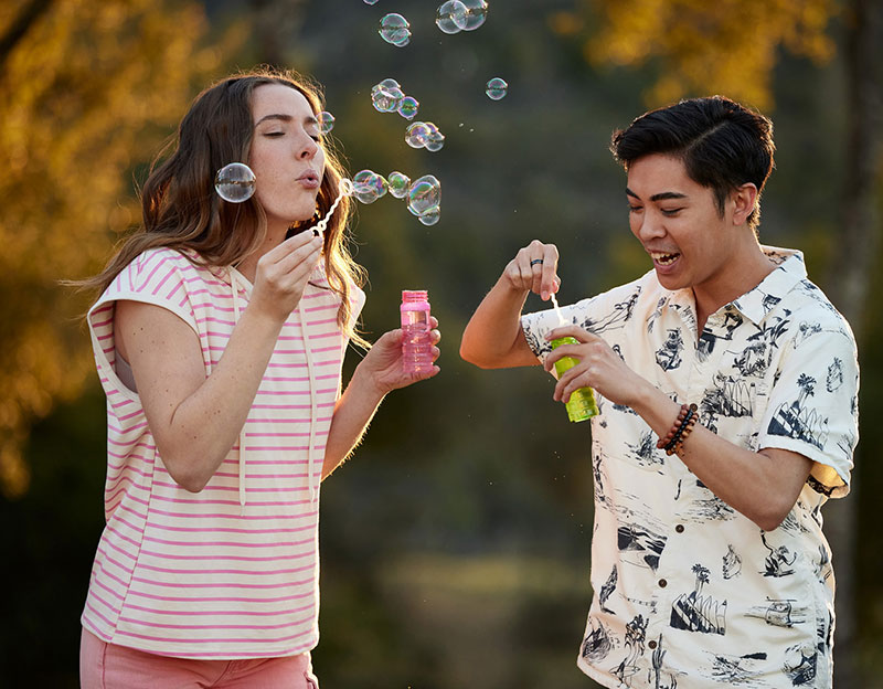 Two people blowing bubbles