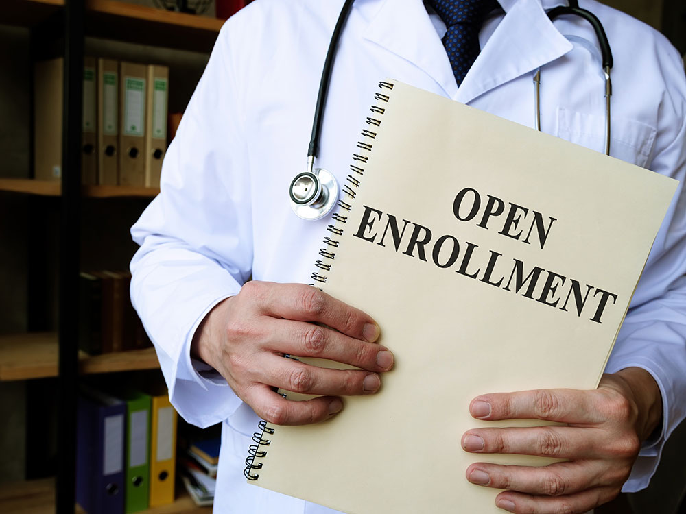 Doctor with notebook that says 'open enrollment'